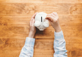Woman Holding A White Piggy Bank